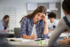 Stressed and worried girl during exam at school