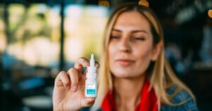 Woman-holding-bottle-of-anti-viral-nasal-spray