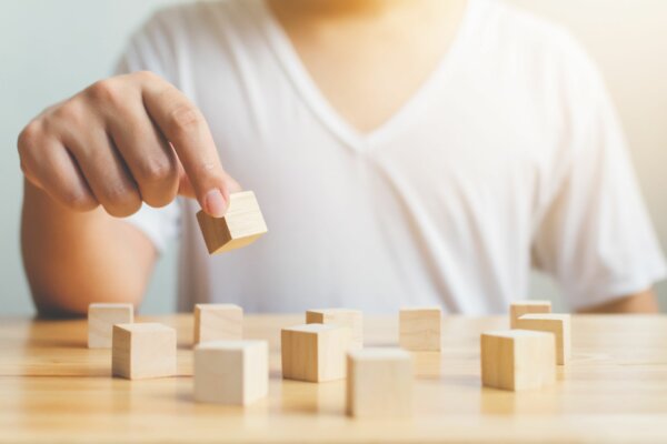 Hand-holding-wood-block-cube- therapy-equipment