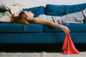 Woman-lying-on-couch-exhausted-droping-red-towel